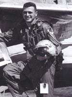 A black and white photograph of Gary with helmet in hand by a U-2.